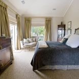 W sypialni stoi komoda z ciemnego drewna.