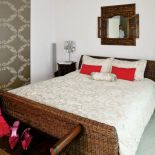 W sypialni uwagę zwraca tapeta zdobiona roślinnymi ornamentami.