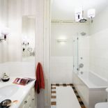 W zabudowanej wnęce schowała się pralka i półka na kosmetyki.