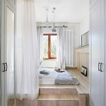 Wąskim przejściem mija się zabudowane szafy, by za chwilę trafić na drewniany podest, na którym leży materac.