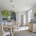 We francuskim XVIII-wiecznym kredensie właścicielka ustawiła zabytkowe buteleczki apteczne wyszukane na aukcjach.