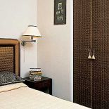 Wezgłowie łóżka wytapicerowano jedwabiem. W podobny sposób potraktowano drzwi obok, dodając im dla urody i