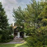 Widok na dom z ogrodu. Drewniany dworek po latach