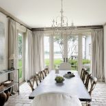 Widok z jadalni rozciąga się na zatokę. Nastrój relaksu podkreślają też lniane zasłony i wypłowiałe błękity.