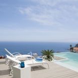 Wielki taras z leżakami i basenem. Willa w stylu marynistycznym