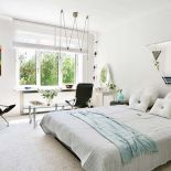 W sypialni kolorowy akcent w postaci obrazu Dominika Winiarskiego. Ciekawe jest też trapezowe lustro nad łóżkiem i oświetlenie.