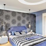 Sypialnia w stylu glamour: welurowa tapeta, łóżko z wysokim zagłówkiem, nowoczesne lampy.