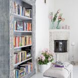 Właścicelka z projektantką przemalowały stare meble, belki pod sufitem, a nawet fugi w kominku.