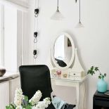 Biała toaletka w stylu art deco i nowoczesne lampy.