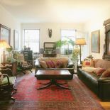 Wokół kwadratowego stołu stoją skórzane kanapy i fotele.