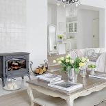 Wolnostojący kominek pasuje do białego wnętrza.