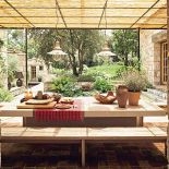 Wprost z kuchni wychodzi się na taras osłonięty bambusowym dachem. Blat stołu został zrobiony z