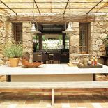 Wprost z kuchni wychodzi się na taras osłonięty bambusowym dachem. Blat stołu został zrobiony z