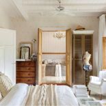 Duża jasna sypialnia powstała z połączenia dwóch pokoi. Komoda, fotel i manekin to antyki.