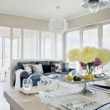 Wszędobylską biel przełamuje szara kanapa. Poduchy są od Decolor i Riviery Maison.