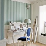 Wszystkie szpargały potrzebne projektantowi sprytnie ukryto w zabudowie pod oknem. N aścianie ręcznie malowana tapeta