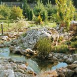 Wygląda niemal jak naturalny, ale płynący przez ogród potok to dzieło rąk ludzkich.
