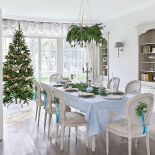 Z jadalni, w której stoi wigilijny stół, widać salon z choinką.