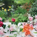 Z kwiatów z własnego ogrodu właścicielka układa bukiety.