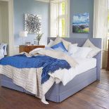 Łóżko Servant (14 100 zł) obite błękitną tkaniną z dopasowaną kolorystycznie pościelą.