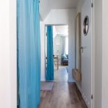 Zamiast drzwi do poszczególnych pomieszczeń, zawieszono turkusowe kotary, które nadają wnętrzu marynistyczny charakter.