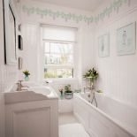 Zamiast kafelków - panele ścienne. Nad nimi, pod sufitem, namalowano kwiatową bordiurę.