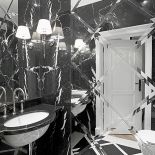 Żeby rozjaśnić łazienkę, jedną ze ścian wyłożono płytkami z fazowanych luster.