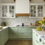 zielona kuchnia z białymi witrynkami