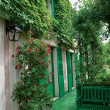 Zielone okiennice i elementy małej architektury ogrodowej sprawiaj, że dom wtapia się w ogród.