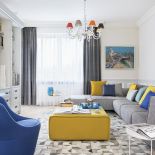 Żółty puf, białe stoliki, poduchy i dywan z kawałków skóry przyjechały z BoConcept. Na ścianach obrazy Dariusza Żejmy z