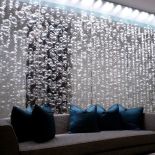 Zrealizowana fantazja właściciela domu w postaci świecącej kotary wykonanej z dmuchanych szklanych baniek o różnych