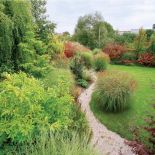 Żwirowa ścieżka gubi się w gęstwinie kolorowych traw. OGRODY DANKIEWICZ