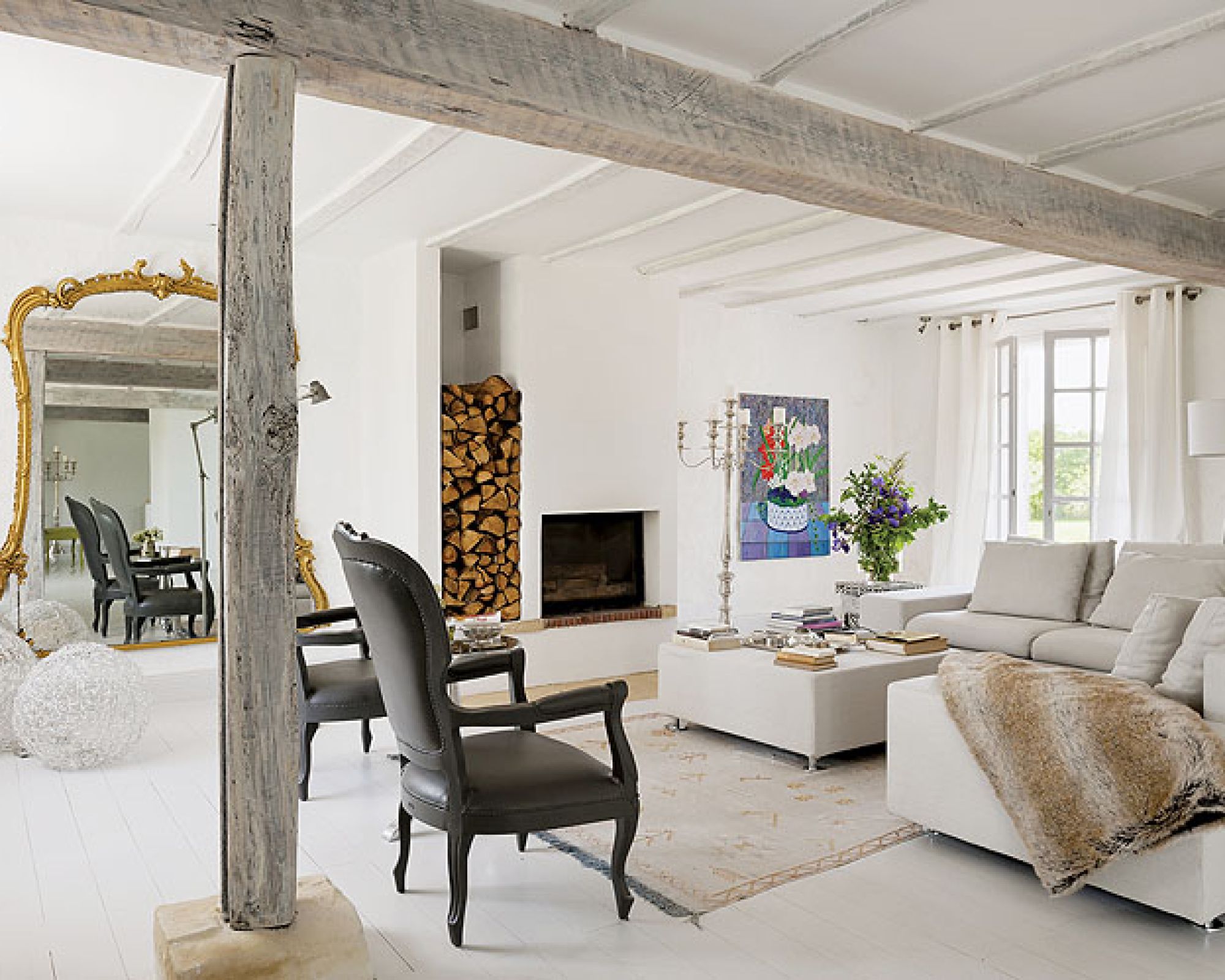 Prosty salon ożywiają: bogate lustro, czarne ludwiki, kandelabr i obraz Jeana de Paula.