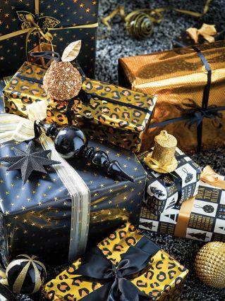Efektowne pakowanie prezentów: papier z brokatem i wyszukane wzory, na przykład w panterka lub pawie pióra.