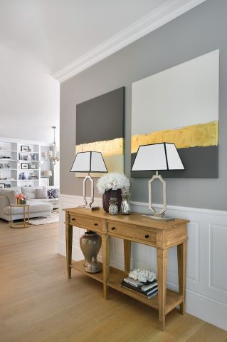 W holu typowe dla stylu Hampton klasyczne sztukaterie. Nowoczesny akcent – obrazy Ivy Białopiotorwicz. Projektantki