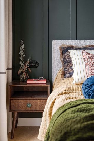 ciemny kolor ścian w sypialni i kontrastowe poduszki