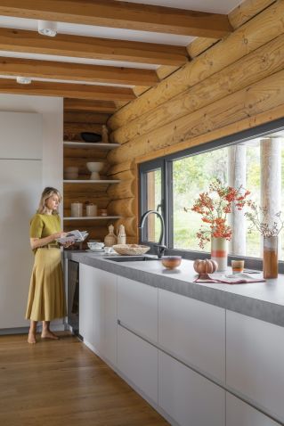 biała kuchnia z drewnem w domu z bali