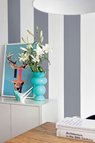 Ściana w malowane pasy. Obraz z jelonkiem i łanią na vespie, namalowany przez Lecha Batora.