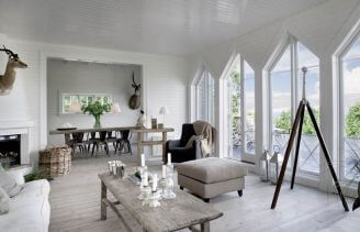 W białym salonie w stylu skandynawskim podziwiać można stolik kawowy i konsolkę firmy Rosmosegard.