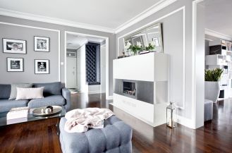 Nowoczesny kominek obłożony ciepłym i miłym w dotyku corianem.