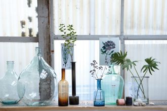 Butelki-flakony z kolorowego szkła będą efektowną dekoracją zarówno mieszkań w chłodnym stylu skandynawskim, jak i