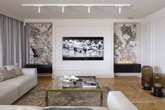 telewizor w salonie obramowany sztukaterią i biokominkiem w kamiennej obudowie