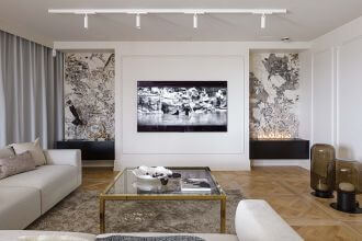 telewizor w salonie obramowany sztukaterią i biokominkiem w kamiennej obudowie