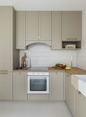 beżowa kuchnia z drewnianymi blatami i mosiężnymi uchwytami