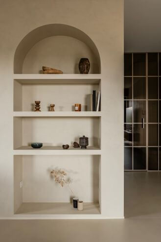 wnęka w kształcie łuku z półkami na książki i dekoracyjne przedmioty