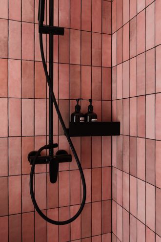 łazienka z różowymi płytkami i czarnymi dodatkami