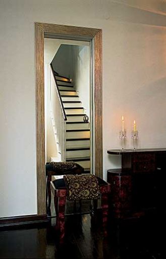 Dwa w jednym - drzwi do garderoby i lustro, w którym malowniczo odbijają się schody. Po przesunięciu szklanej tafli