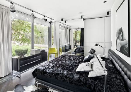 Sypialnia z panoramicznym oknem i dizajnerskimi smaczkami: stojace lampy Tolomeo (marki Artemide), czy poduszki z