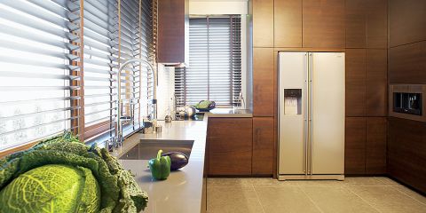 Minimalistyczna kuchnia stała się przytulniejsza dzięki kolorom, czekoladowym brązom i odcieniom cafe latte.