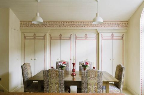 W kuchni stół i krzesła obszyte wzorzystymi tkaninami.